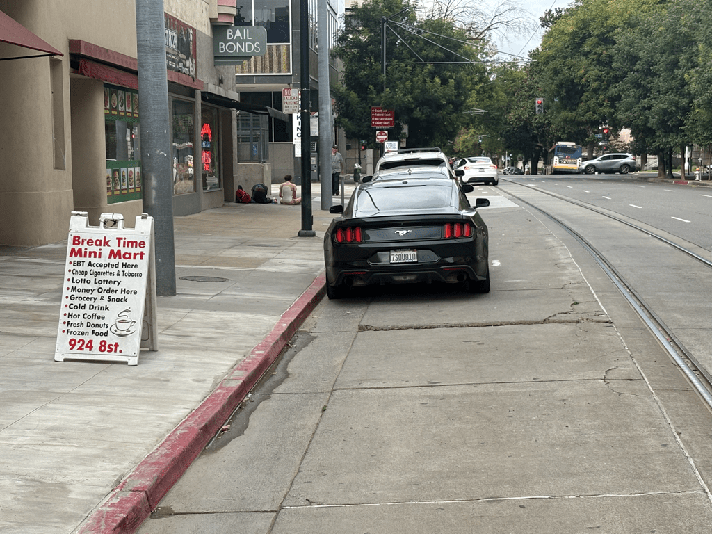 photo of illegal parking adjacent to Gold Line light rail tracks, 7th St north of J St